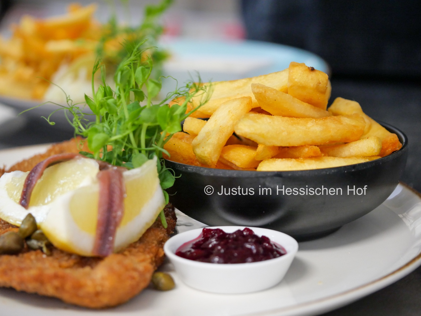 Gericht mit Pommes und Preiselbeeren